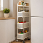 A tall white rolling kitchen organizer cart with four mesh baskets, shown in a kitchen next to a refrigerator and counter.